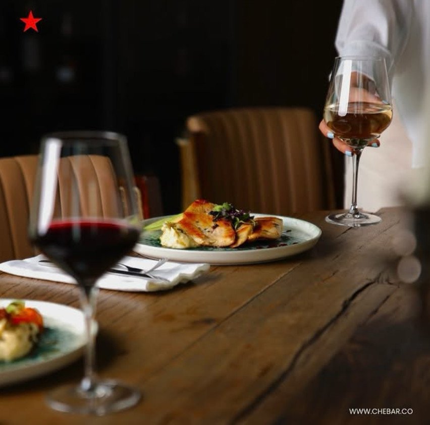 A warm table, comforting food, and a glass of wine in hand